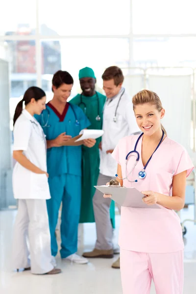 Enfermera con colegas en segundo plano —  Fotos de Stock