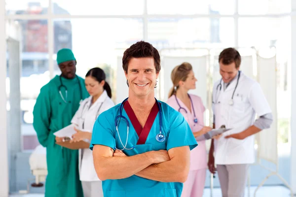 Attraktiva läkare med är team i bakgrunden — Stockfoto