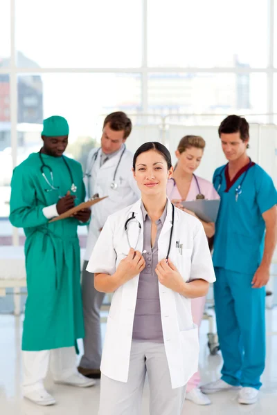 Vrouwelijke arts met haar team in de achtergrond — Stockfoto