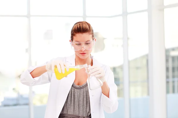 Ξανθιά γυναίκα επιστήμονα examinig ένα δοκιμαστικό σωλήνα — Φωτογραφία Αρχείου