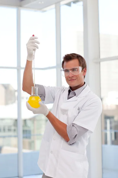 Scientist examining a test-tube looking at the camera — Stock Photo, Image
