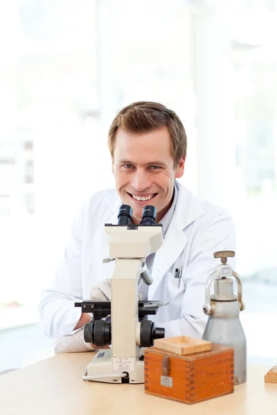 Cientista masculino olhando através de um microscópio com espaço de cópia — Fotografia de Stock