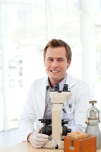 Científico masculino mirando una diapositiva bajo un microscopio —  Fotos de Stock