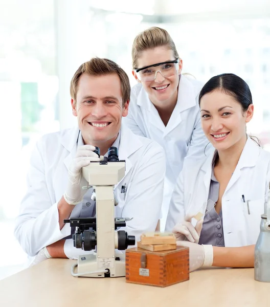 Молодые ученые, работающие с микроскопом — стоковое фото
