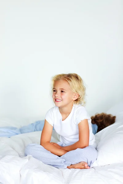 Kislány ült az ágyban, copyspace — Stock Fotó