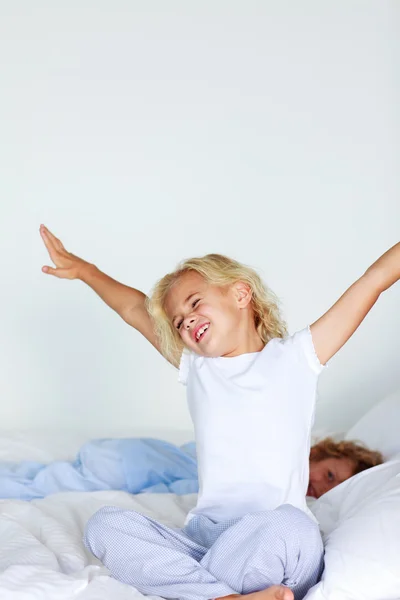 Little girl stretching in bed — Stock Photo, Image