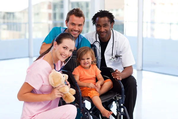 Little patient with medical team smiling at the camera — Stock Photo, Image