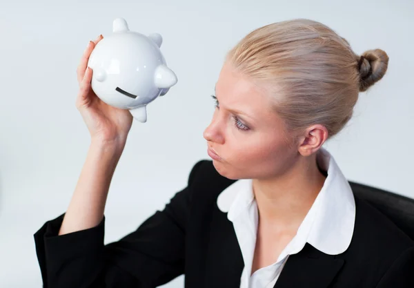 Triste mujer de negocios mirando en Piggy Bank — Foto de Stock