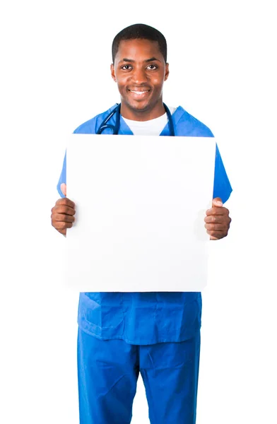 Guapo médico vistiendo uniformes y mostrando una tarjeta blanca —  Fotos de Stock
