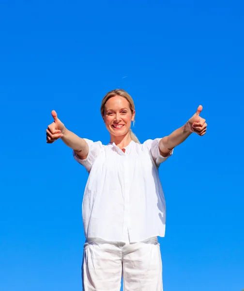 Young woman doing exercises with thumbs up — Stock Photo, Image