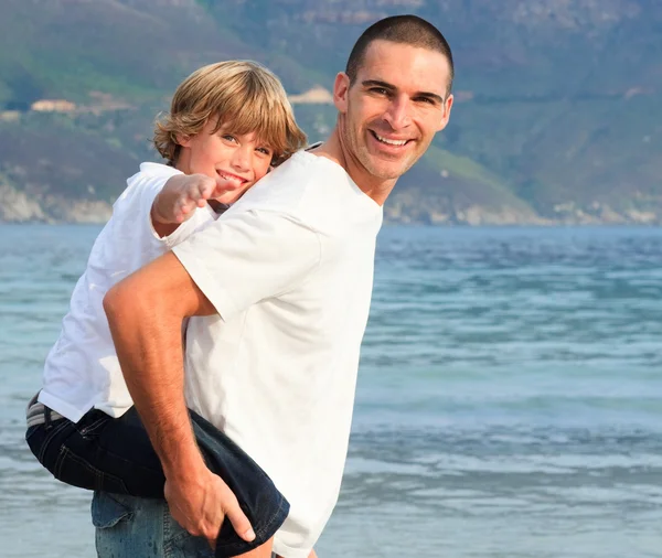 그의 아들 피기백 해변에서 탈 주는 아버지 — 스톡 사진