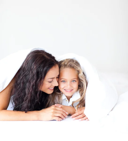 Hermosa madre y su hija mirando a la cámara en la cama —  Fotos de Stock