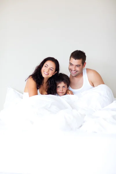 Сім'я грає зі своїм сином в ліжку з копіювальним простором — стокове фото
