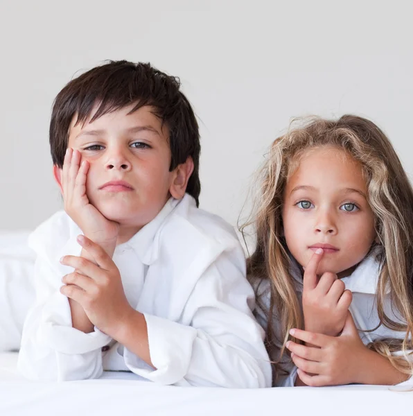 Little children sitting on a bed — Stock Photo, Image