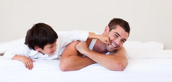 Ojca i syna, zabawy na łóżku — Zdjęcie stockowe