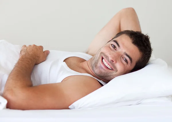 Jóképű férfi az ágyon — Stock Fotó