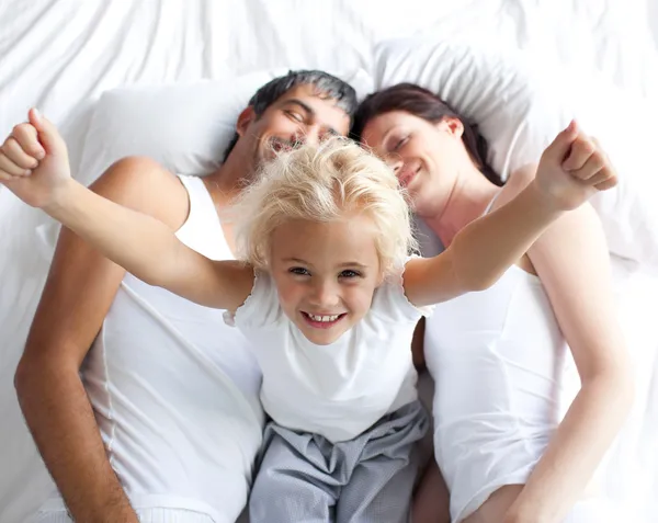 Menina feliz na cama com seus pais — Fotografia de Stock