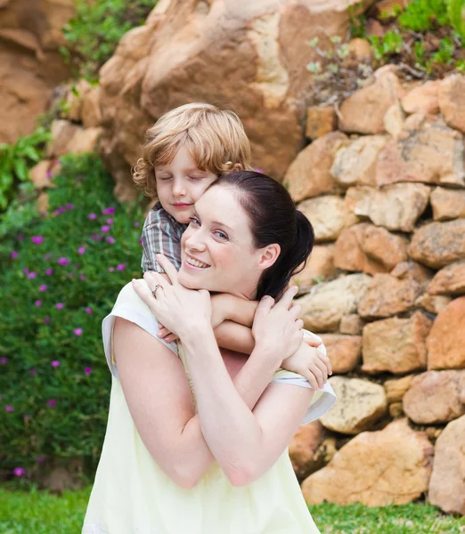 Moeder geven zoon piggyback — Stockfoto