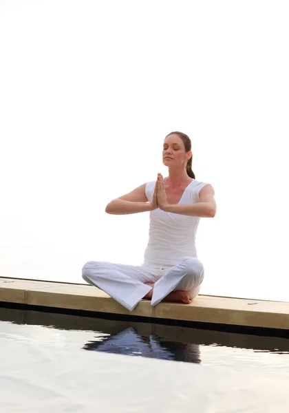 Kvinnan gör yoga nära havet — Stockfoto
