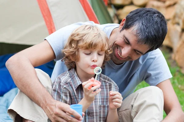 Father and son having fun with bubbles — Stock Photo, Image