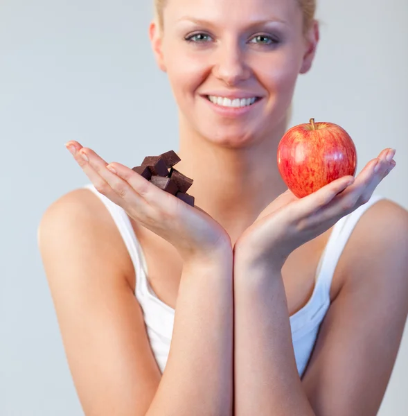 Blonde woman showing chocolate and apple focus on chocolate and apple — Stock Photo, Image