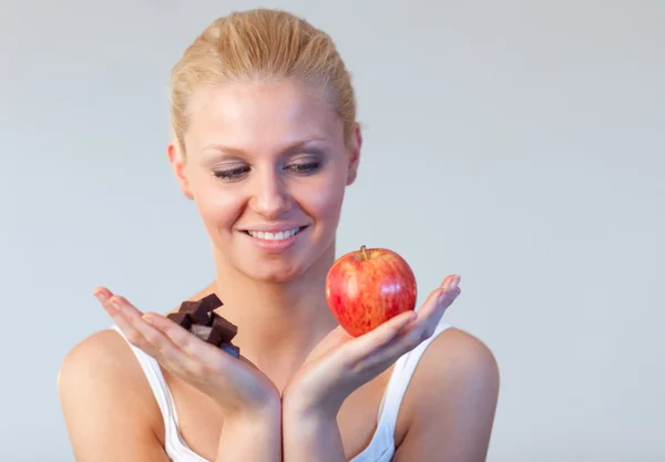 Mujer amigable sosteniendo chocolate y manzana se centran en la mujer —  Fotos de Stock