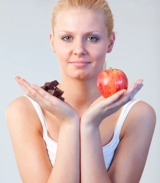 Beautiful woman holding chocolate and apple focus on woman — Stock Photo, Image