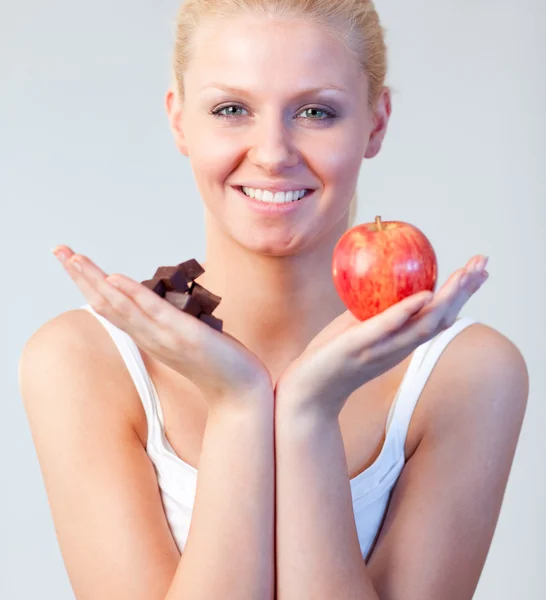 Mulher amigável segurando chocolate e foco de maçã na mulher — Fotografia de Stock