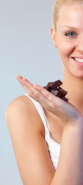 Närbild av en attraktiv kvinna håller choklad fokus på kvinna — Stockfoto