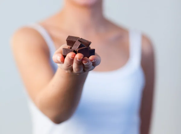 Close-up of woman holding chocolate focus on chocolate — Stock Photo, Image
