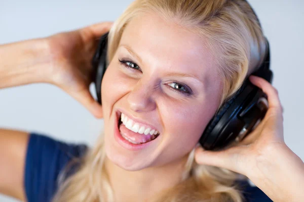 陽気な女性のヘッドフォンで音楽を聴く — ストック写真