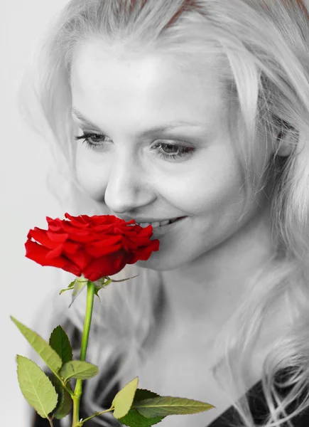 Mujer sonriente en blanco y negro oliendo una rosa roja —  Fotos de Stock