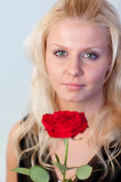 Vacker kvinna med en ros med fokus på kvinna — Stockfoto