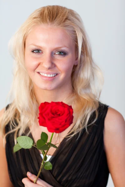 Retrato de uma mulher atraente com uma rosa com foco na mulher — Fotografia de Stock