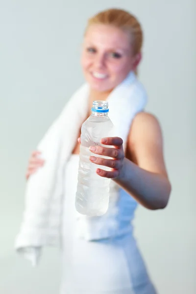 Mujer sonriente con una botella de agua y una toalla con foco en el agua — Foto de Stock