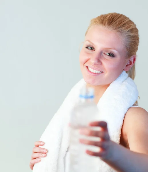 Close-up of an attractive woman holding a bottle of water and a towel focus on woman — Stock Photo, Image