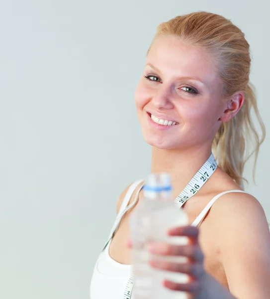 Närbild av en glad kvinna med en flaska vatten fokus på kvinna — Stockfoto
