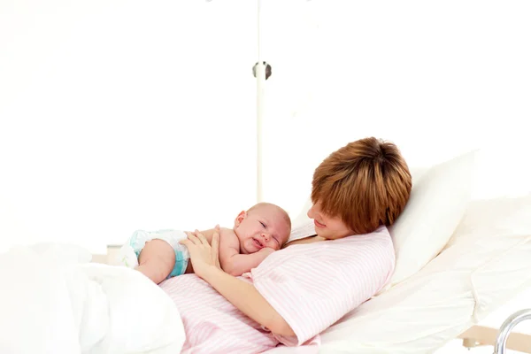 Paciente hablando con su bebé recién nacido en la cama — Foto de Stock