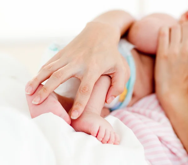 Mãos de paciente segurando um bebê recém-nascido na cama — Fotografia de Stock