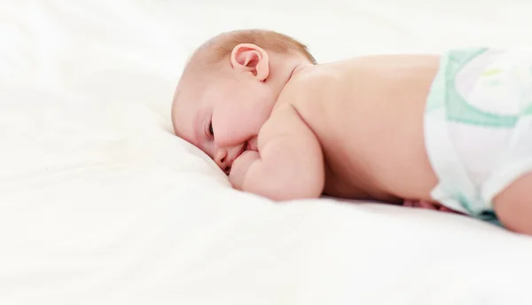 Baby sleeping in bed with his finger in his mouth — Stock Photo, Image