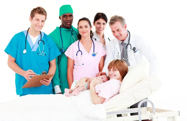 Médicos que atendem uma mãe e seu bebê recém-nascido — Fotografia de Stock