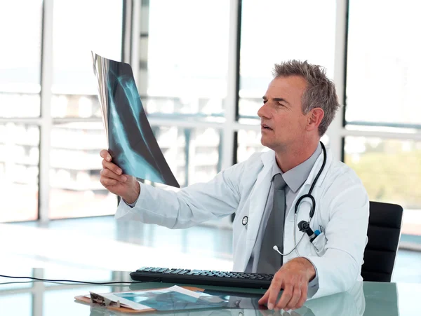 Зрелый мужчина-врач осматривает рентген — стоковое фото