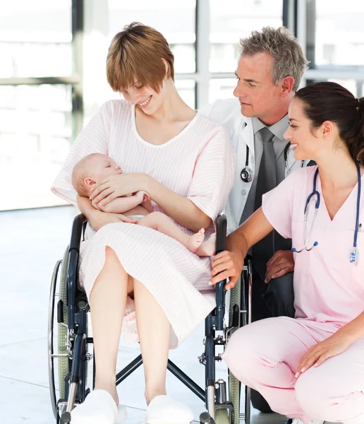 Patiënt met haar pasgeboren baby en artsen — Stockfoto