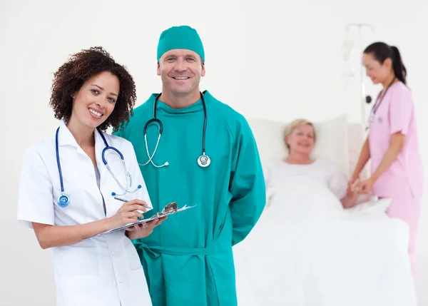 Portrait de médecins souriants examinant un patient — Photo