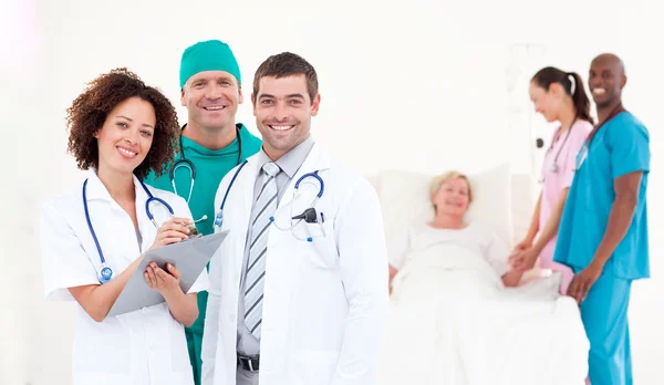 Portrait de médecins souriants examinant un patient — Photo