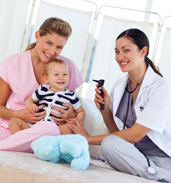 Dziecko z pediatra i pielęgniarki uśmiechając się do kamery — Zdjęcie stockowe