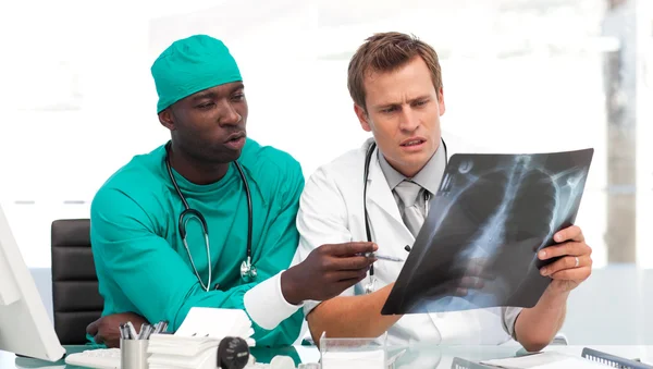 Two doctors examining an x-ray — Stock Photo, Image