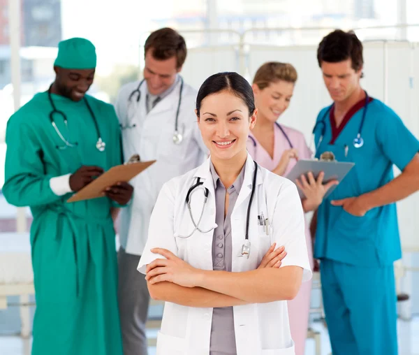 Aantrekkelijke vrouwelijke arts met haar team — Stockfoto