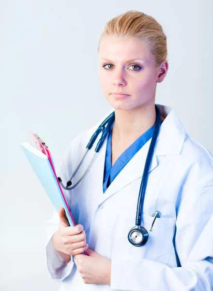 Médico serio sosteniendo un portapapeles —  Fotos de Stock
