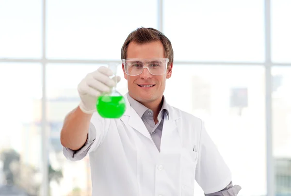 Científico sonriente examinando un tubo de ensayo — Foto de Stock